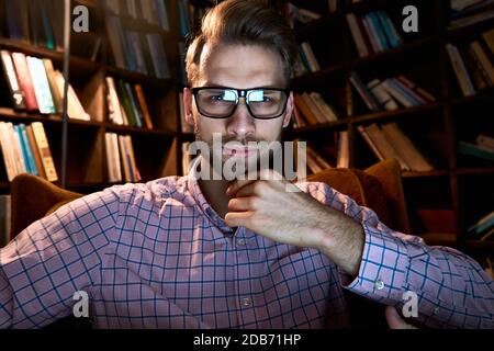 Serious young businessman looking at webcam conference calling watching webinar. Stock Photo