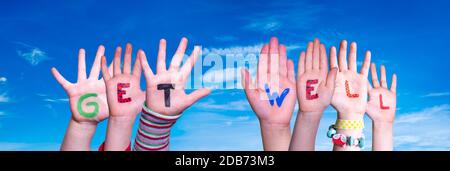 Children Hands Building Colorful English Word Get Well. Blue Sky As Background Stock Photo