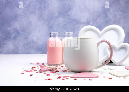 Round Cup with a drink on a romantic background with a frame and bottles of milk drink on a white and purple background. Stock Photo