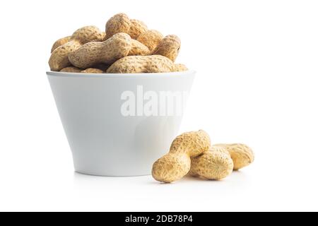 Tasty unpeeled peanuts in bowl isolated on white background. Stock Photo