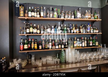 Large assortment of alcoholic beverages in bottles displayed on shelves in a cafe or bar Stock Photo