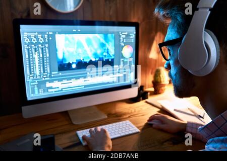 Male videographer editor using pc computer editing footage at home office. Stock Photo