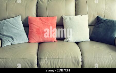 Full frame shot of light brown leather sofa with color suede pillows. Stock Photo