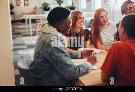 Group of multi-ethnic students in classroom. Study group sitting at table and smiling in university. Stock Photo