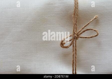 Twine tied in a bow. Close-up. Fabric background Stock Photo
