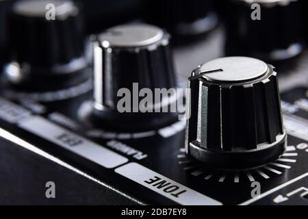selective focus on the tone knob of an amplifier for electric musical instruments Stock Photo
