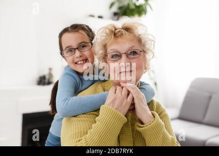 Portrait of happy old grandmother and kid girl waving hands looking at  camera, smiling grandma with granddaughter making video call, child and  granny vloggers recording video blog or vlog together Stock Photo