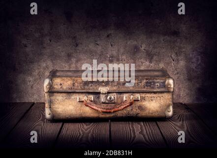 Old shabby suitcase on dark background Stock Photo