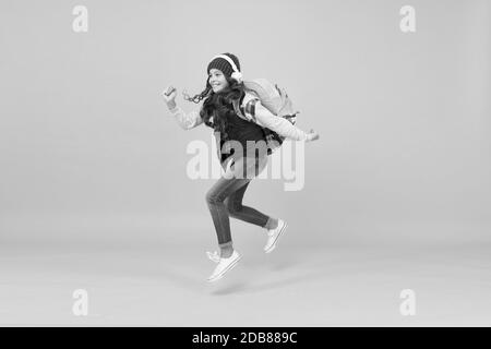 Finally graduated. child being late. sense of freedom. childhood activity. little girl listen music in headphones. back to school. small schoolgirl running to school. hurry up its holiday time. Stock Photo