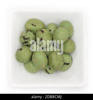 Wasabi peanuts snach in a white bowl in top view Stock Photo
