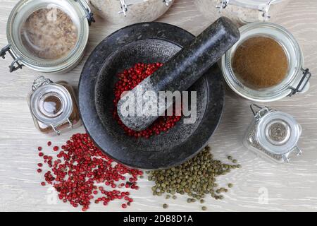 pepper corns and mortar and pestle grinder from top Stock Photo