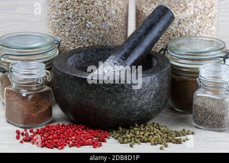 A close up side view of jars of spices and pepper corns ready for grinding Stock Photo