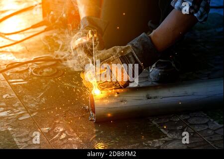 Close-up of a man welding steel pipes, Thailand Stock Photo