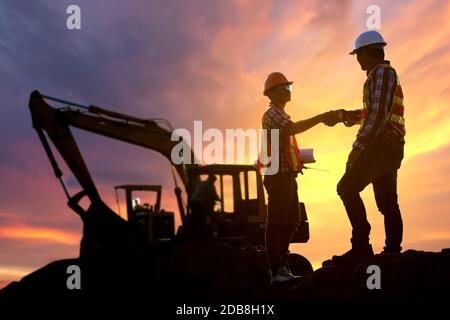 Two engineers shaking hands on a construction site, Thailand Stock Photo