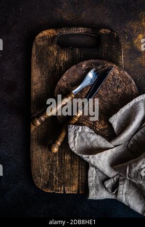 Rustic cutlery on wooden chopping boards Stock Photo