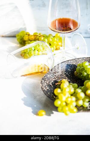 Glasses of red and white wine with green grapes Stock Photo