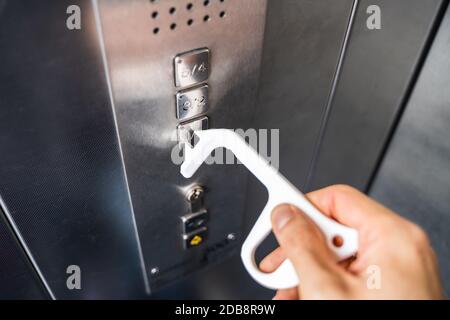 Man Using Contactless Tool To Press Button To Protect From Coronavirus Infection Stock Photo