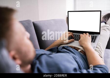 Cropped Image Of Young Man Using Laptop At Home Stock Photo
