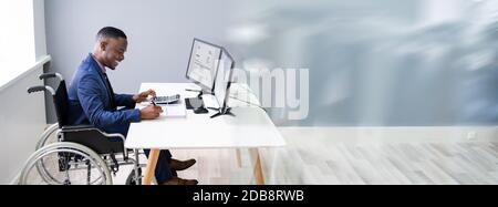 Disabled African Accountant Working On Computer In Wheelchair Stock Photo
