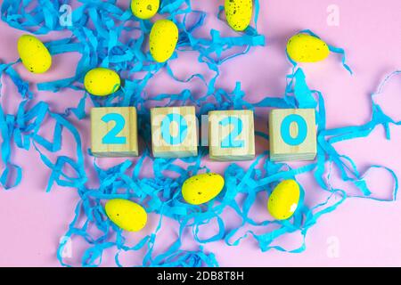 Word Easter on wooden cubes and surrounded with multiple egg decorations as a festive Easter background composition. Stock Photo