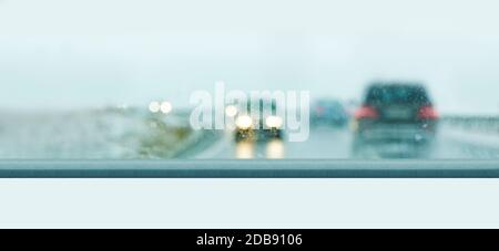 Car traffic on a rainy day seen through a wet windshield. Stock Photo