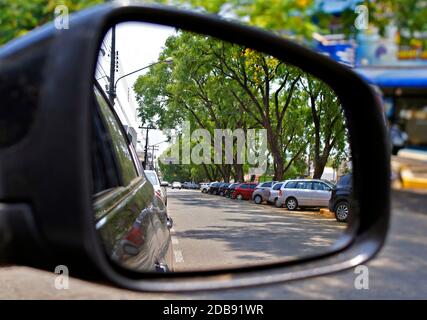 View of many cars parked by the rear view mirror in a small city in Brazil. Stock Photo