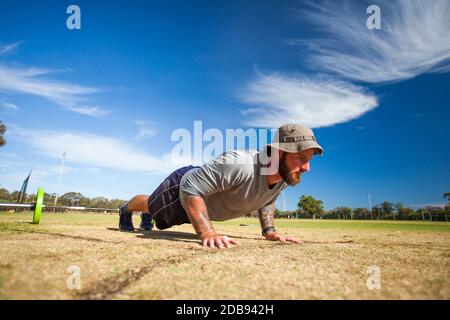 Man doing push-ups outdoors Stock Photo