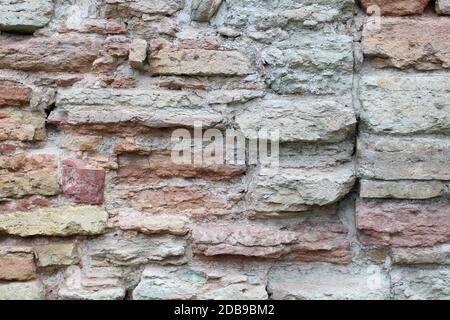 Destroyed by time and precipitation brick wall. The Background of old vintage brick wall Stock Photo