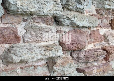 Destroyed by time and precipitation brick wall. The Background of old vintage brick wall Stock Photo