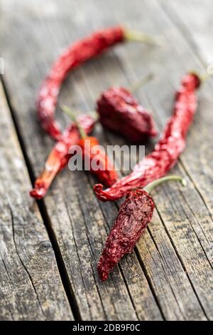 Dried red chili peppers on wooden table. Stock Photo