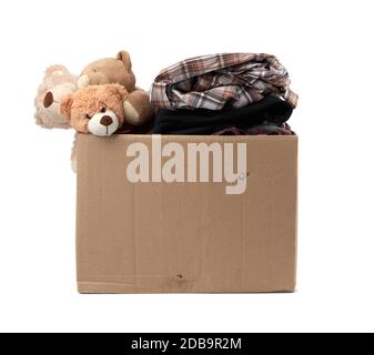 large brown cardboard box filled with things and children's toys, concept of moving, volunteering and help Stock Photo