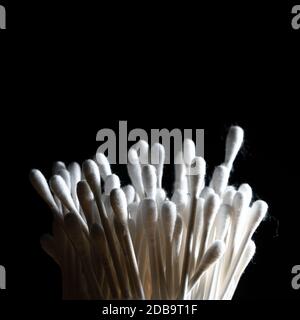 container of cotton buds in backlight on a black background Stock Photo