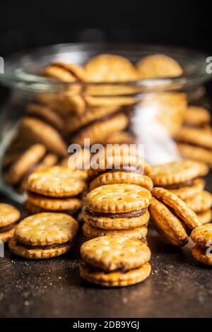 Mini cream sandwich cookies on black table. Stock Photo