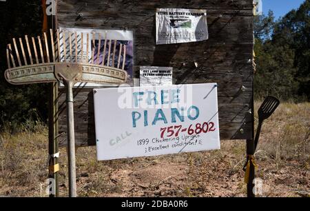 A sign at a rustic community bulletin board beside a road in Pecos, New Mexico, offers a free piano to a good home. Stock Photo