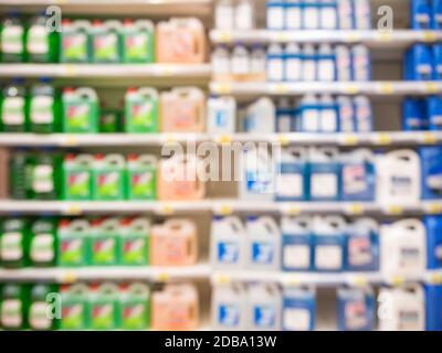 Blurred colorful motor oil bottles on shelves in supermarket as background Stock Photo