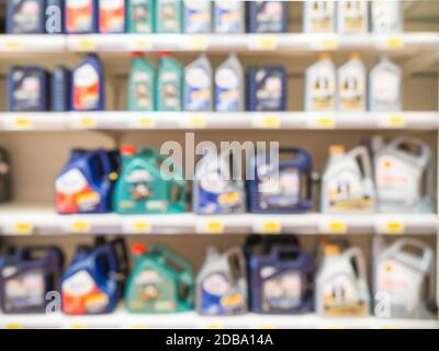 Blurred colorful motor oil bottles on shelves in supermarket as background Stock Photo