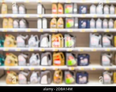 Blurred colorful motor oil bottles on shelves in supermarket as background Stock Photo