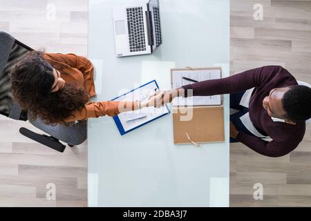 African Man And Middle Eastern Woman Shaking Hands At Interview Meeting Stock Photo