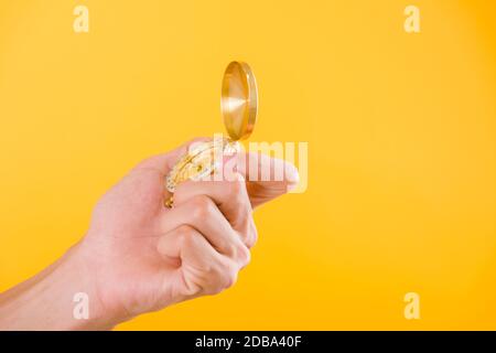 Hand holding antique brass compass isolated on yellow background with copy space for text Stock Photo