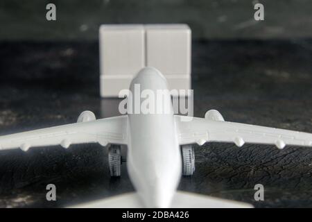 Airplane with wooden cubes on which you can enter your date stands on a dark background. Top views. Stock Photo