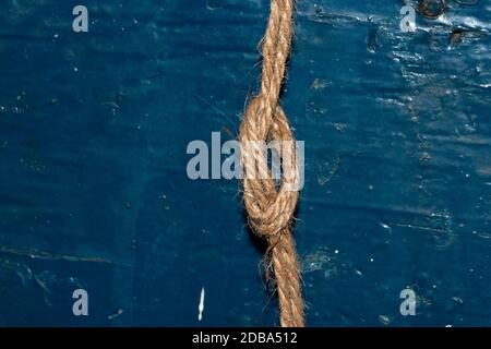 Nautical rope knot on blue wooden background Stock Photo