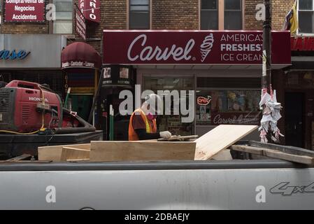A construction worker wearing a mask works in front of his pickup truck in Corona, Queens. Stock Photo