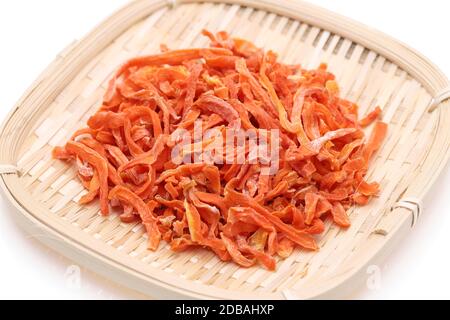 Dried chopped carrots in a bamboo basket isolated on white background Stock Photo