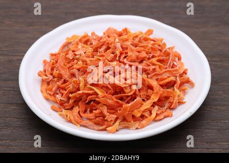Dried chopped carrots in a bowl on table Stock Photo