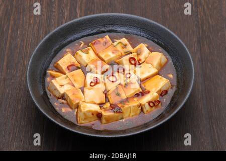 Chinese cuisine mabo tofu in a dish on wooden table Stock Photo