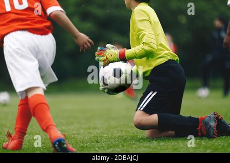 Junior Soccer Football Goalkeeper Catching Ball. Goalie in Action on the Pitch During Match. Goalkeeper on Knees in a Goal Play in a Game Stock Photo Alamy