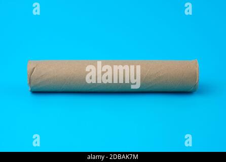brown paper towel from a roll of kitchen towels, object on a blue background Stock Photo