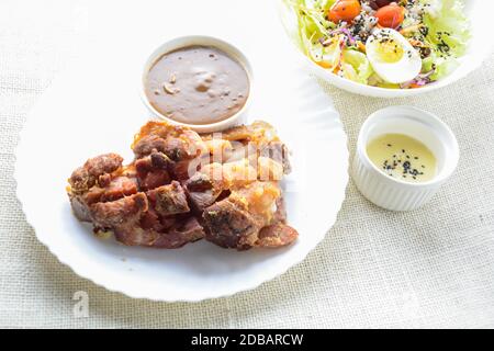 Deep fried pork knuckle with mushroom gravy source, fresh vegetable and salad cream source Stock Photo