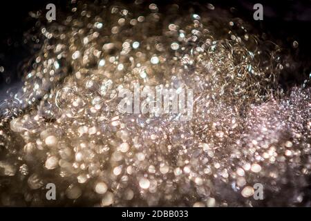 Soap bubbles in a foam carpet with blurred dark areas in the foreground and background Stock Photo