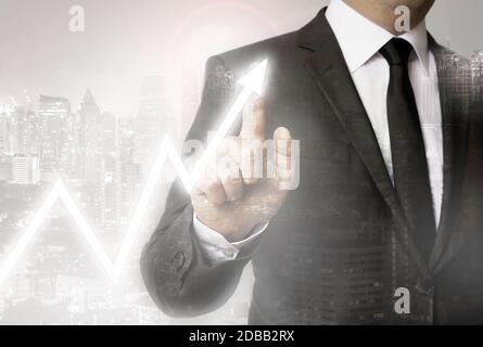 Businessman with city background showing stock market. Stock Photo